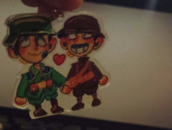 keychain with 2 soldiers on it being held in front of a cinema screen